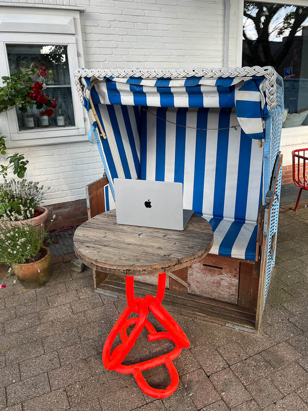 Außergewöhnlicher Tisch mit Laptop vor einem Strandkorb