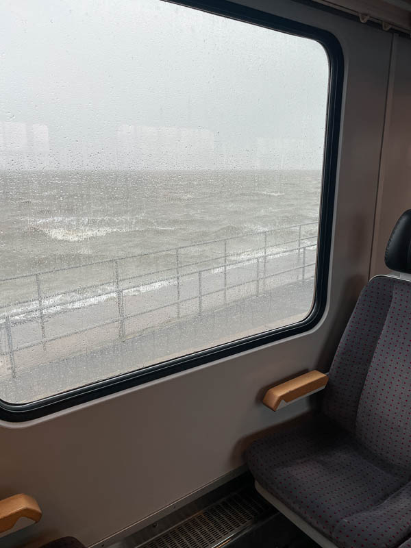 Blick aus dem Zug durchs Fenster auf die Nordsee am Hafen von Dagebüll Mole