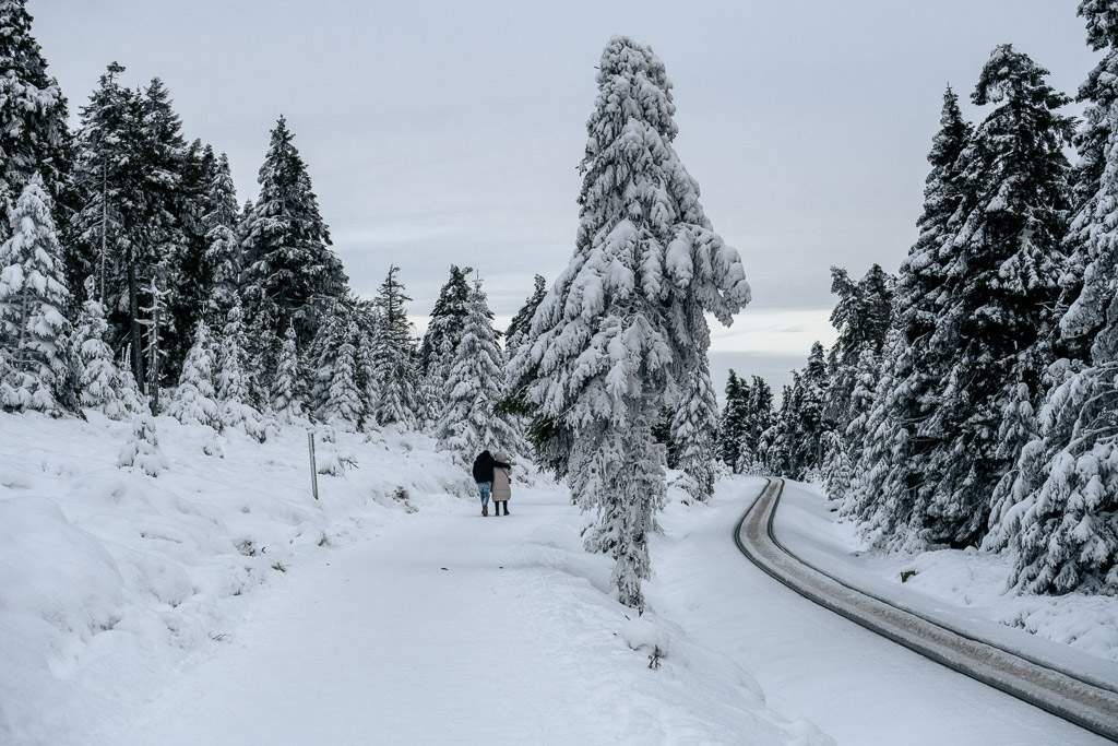 Ein verliebtes Pärchen wandert entlang des verschneiten Goetheweg zum Brocken