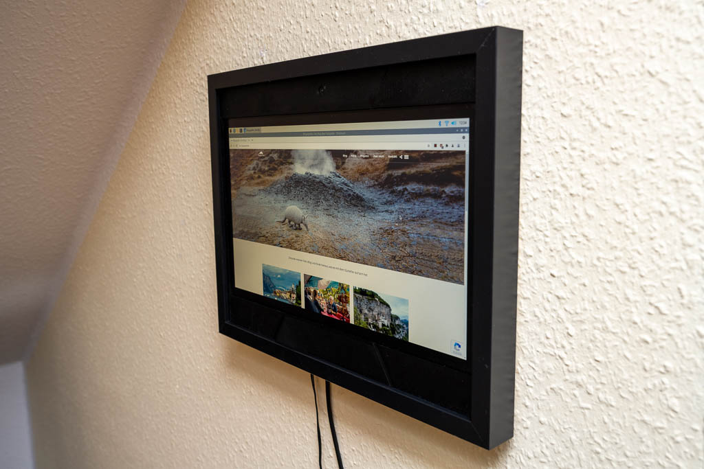 Bilderrahmen mit Laptop-Monitor an der Wand