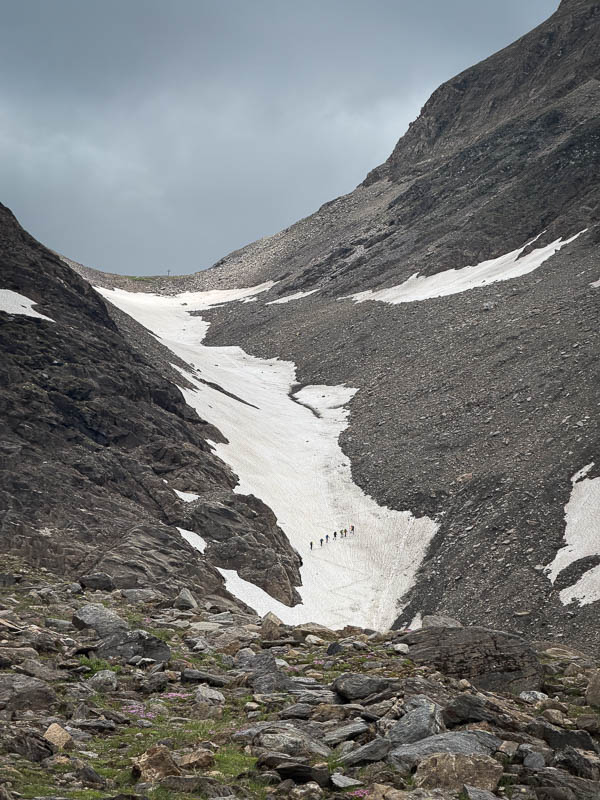 Wandergruppe auf einem Schneefeld unterhalb der Pfandlscharte