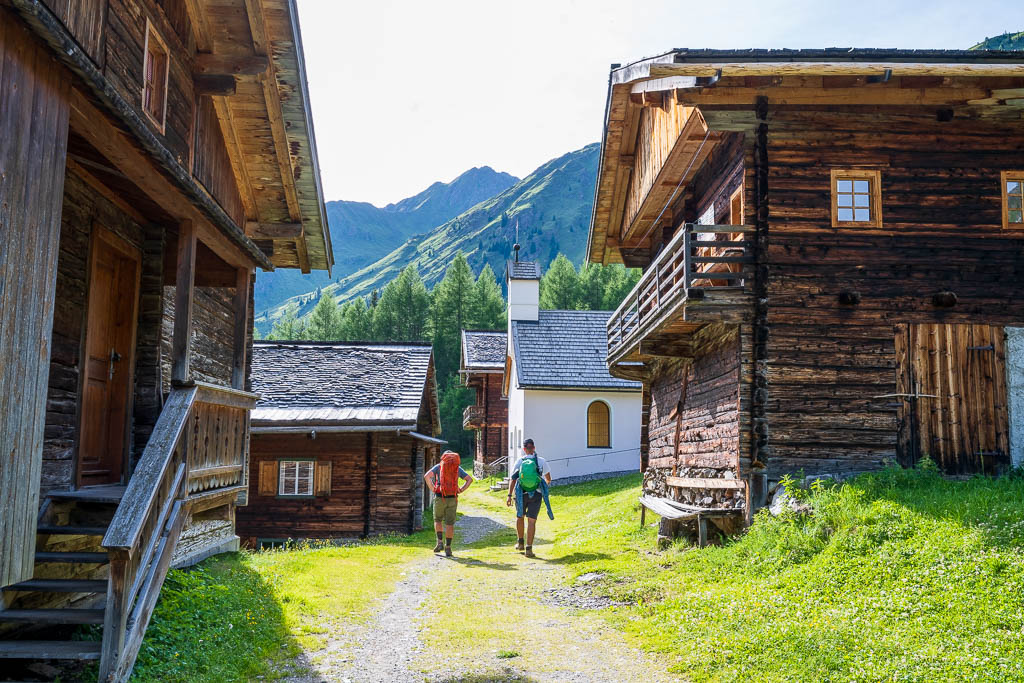 Historische Holzhütten der Oberstalleralm vor der Bergkulisse der Villgratner Berge.