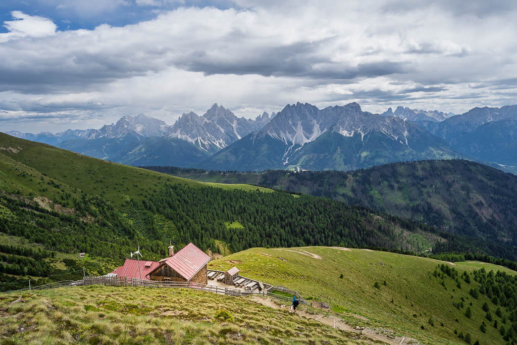 Die Bonnerhütte liegt auf einer grünen Bergwiese mit weitem Blick auf die Dolomiten