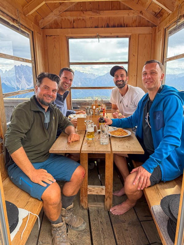 Drei Wanderer sitzen nach der Tour gemeinsam an einem Tisch in der Bonnerhütte