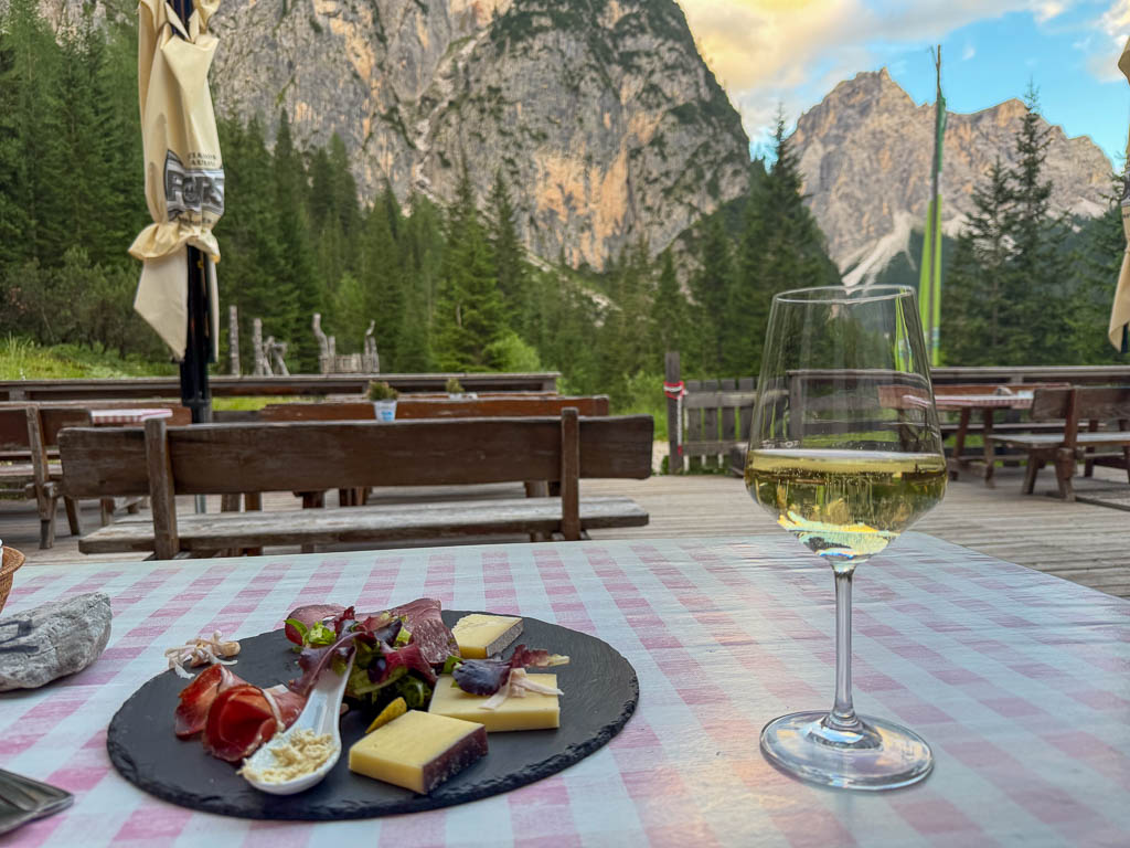 Jause mit Wurst, Käse und Apfelstrudel auf einem Tisch auf der Terrasse der Dreischusterhütte