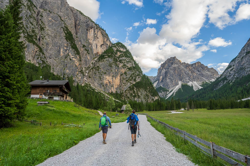 Wanderer nähern sich auf einem Weg durch das grüne Tal der Dreischusterhütte