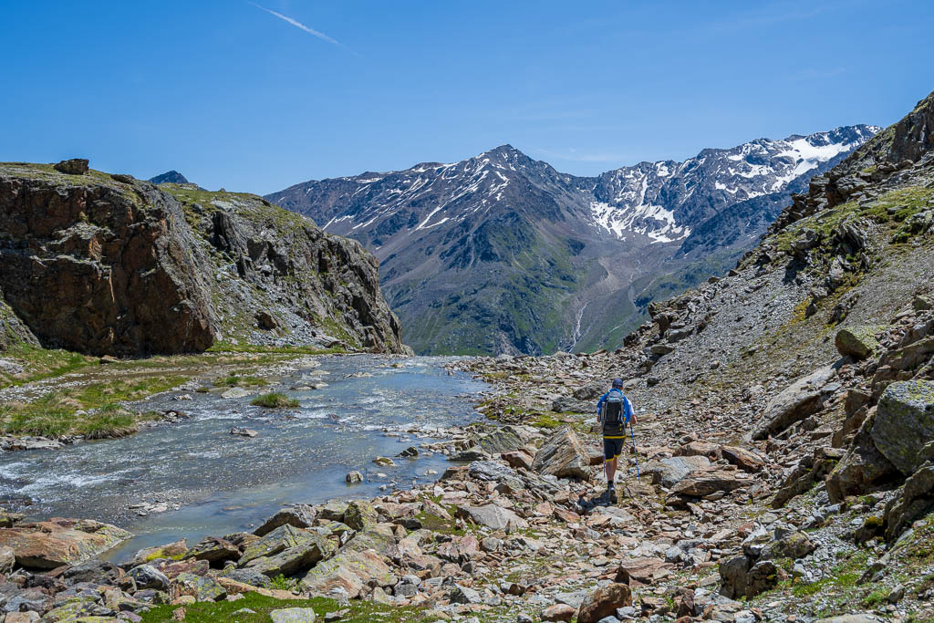 Wanderer an einem Fluss beim Abstieg nach Vent