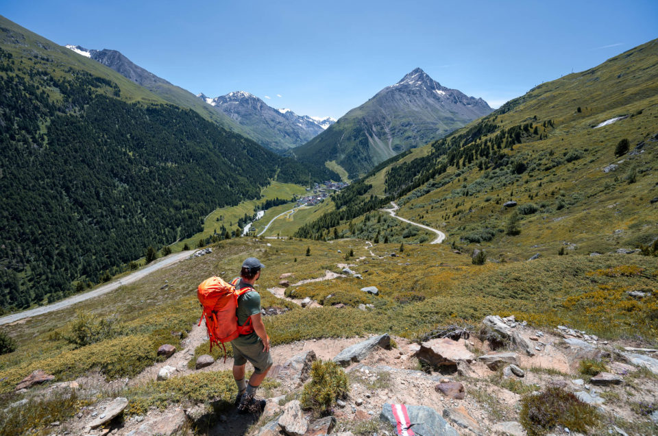 Wanderer guckt hinab aufs Bergsteigerdorf Vent
