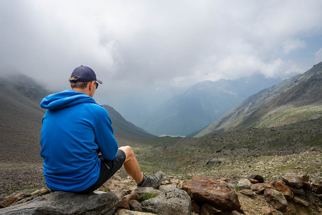 Pause eines Wanderers mit Ausblick auf den Stausee von Vernagt