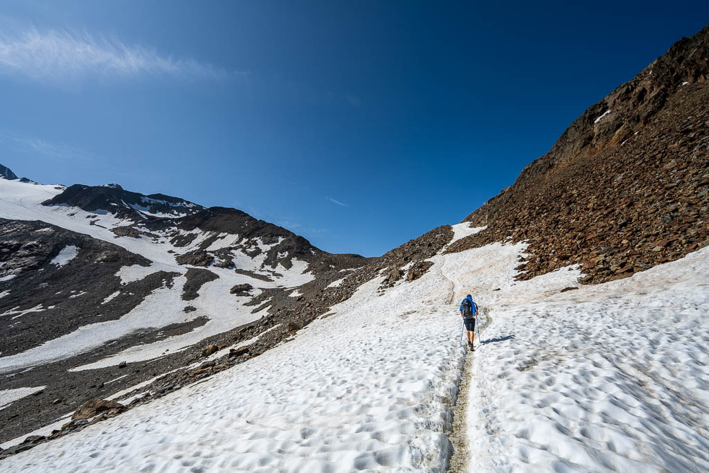 Ein Wanderer überquert Schneefelder beim Aufstieg zur Similaunhütte