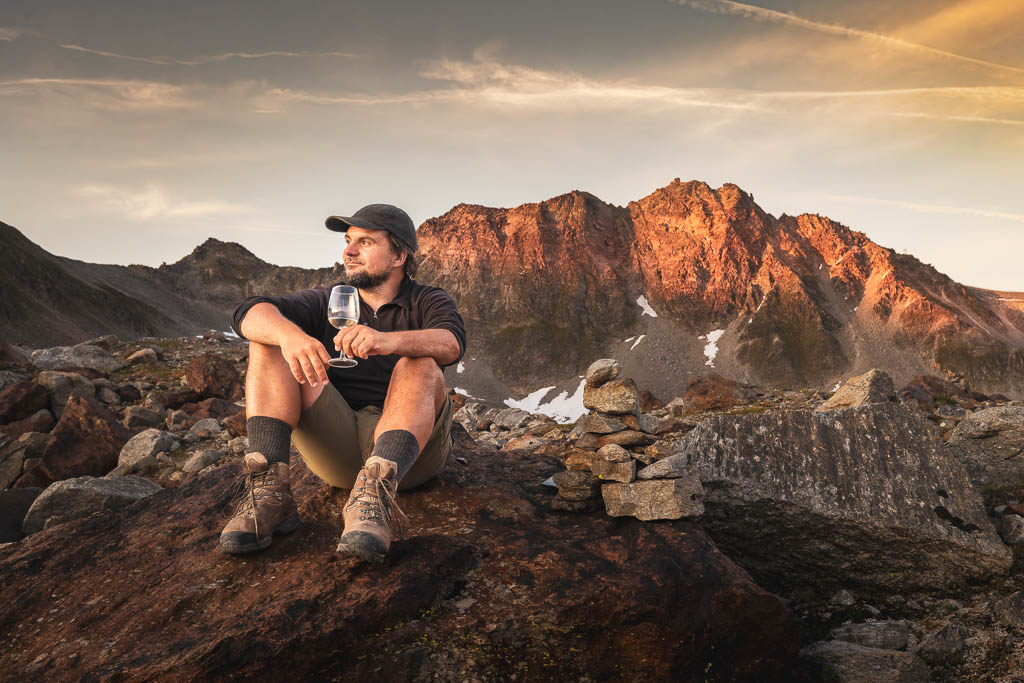 Wanderer mit Weinglas in den Bergen beim Alpenglühen