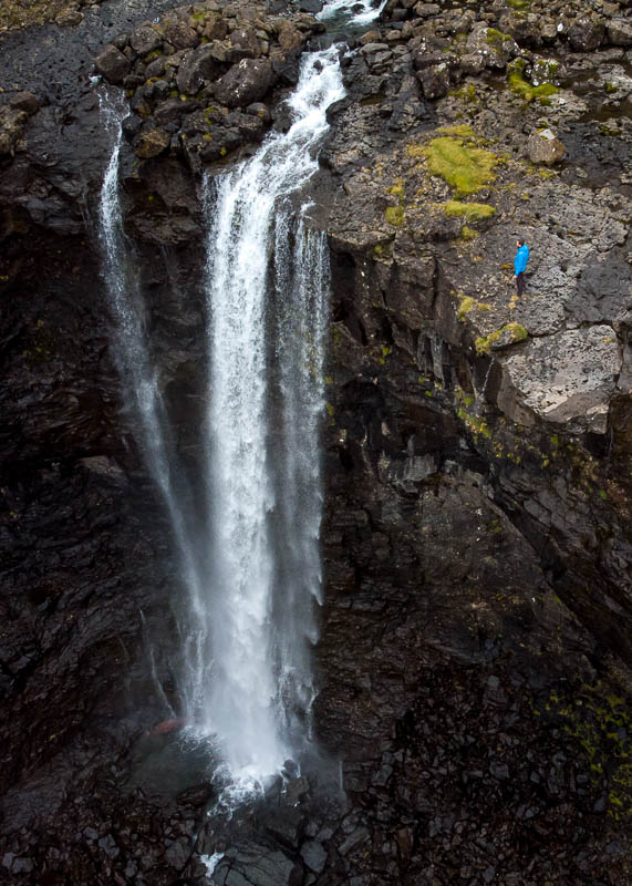 Ein Mensch am Abgrund vom Fossa Wasserfalls auf den Färöer Inseln