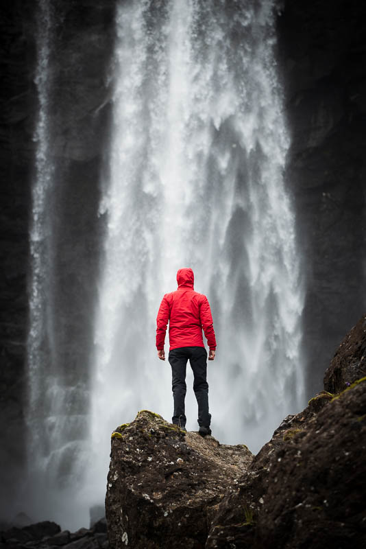Ein Mensch vor den Fluten des Fossa Wasserfalls auf den Färöer Inseln