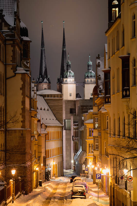Ein Blick auf die Marktkirche von Halle (Saal) bei Nacht im Schnee durch die Rathausstraße