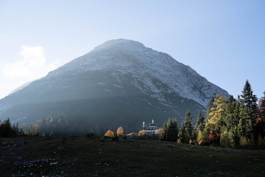 Die Rauthhütte im herbstlichen Abendlicht mit der Hohen Munde im Hintergrund