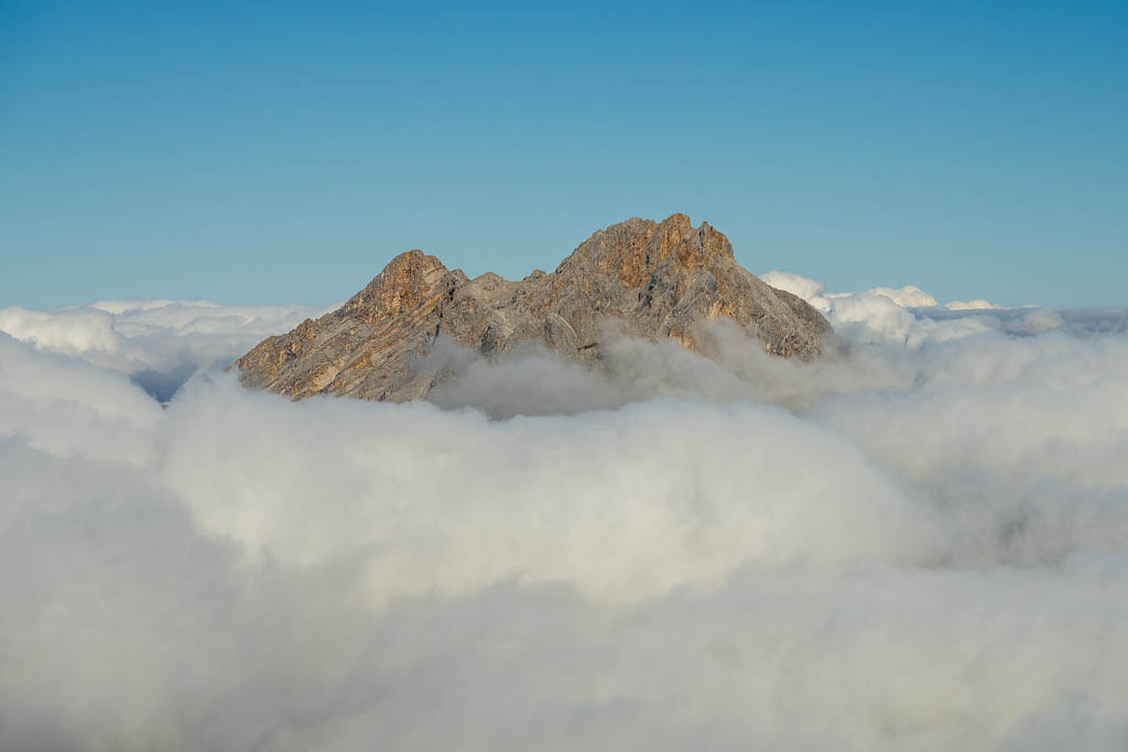 Ein Berggipfel schaut aus den Wolken heraus