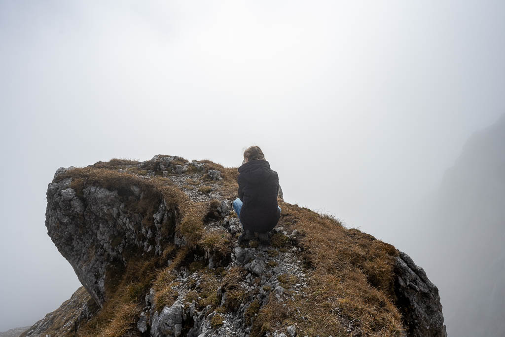 Ein Felsvorsprung im Nebel mit Kind