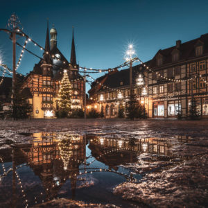 Das weihnachtlich geschmückte Rathaus Wernigerode spiegelt sich in einer Pfütze