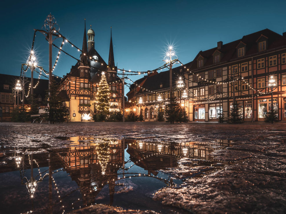 Das weihnachtlich geschmückte Rathaus Wernigerode spiegelt sich in einer Pfütze