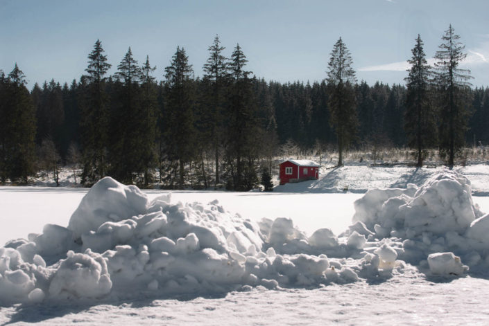 Rote Holzhütte am Ziegenberger Badeteich im Schnee