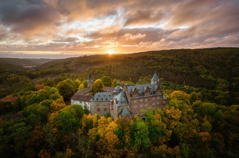Luftaufnahme von Schloss Rammelburg zum Sonnenaufgang im Herbst